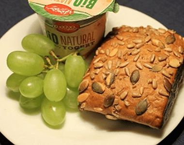 Bílý jogurt s čerstvými hrozny, dýňová bulka